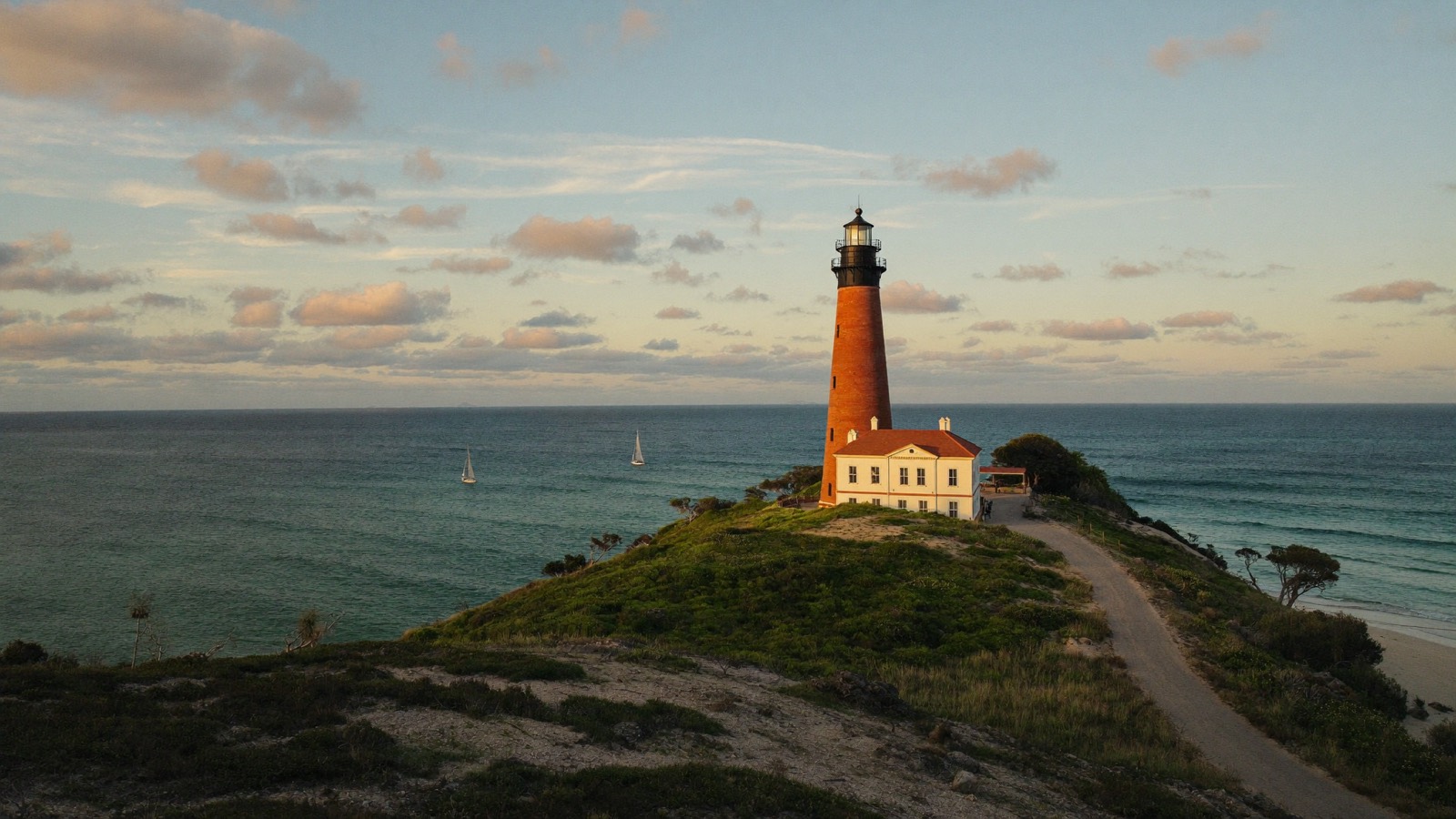 The historic red Jupiter Inlet Lighthouse over the turquoise inlet